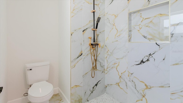 bathroom with toilet, a marble finish shower, and baseboards