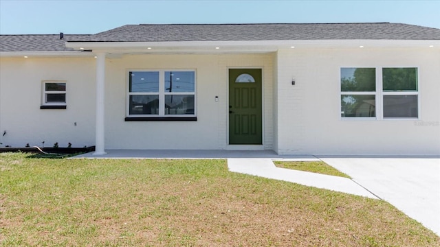 view of front of property with roof with shingles and a front lawn