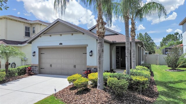 4063 Medicci Ln, Wesley Chapel, FL 33543 - view of front of house with stucco siding, a garage, driveway, and stone siding