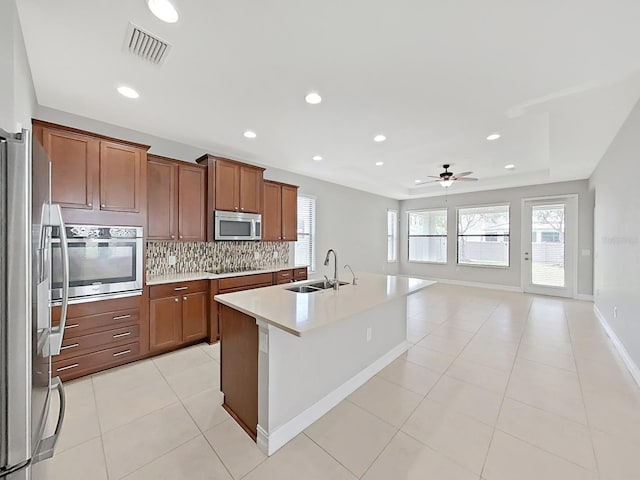 4063 Medicci Ln, Wesley Chapel, FL 33543 - kitchen with a sink, appliances with stainless steel finishes, backsplash, ceiling fan, and light tile patterned flooring