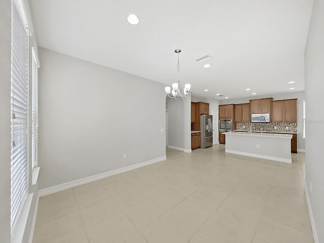 4063 Medicci Ln, Wesley Chapel, FL 33543 - unfurnished living room with a chandelier, recessed lighting, light tile patterned floors, a sink, and baseboards