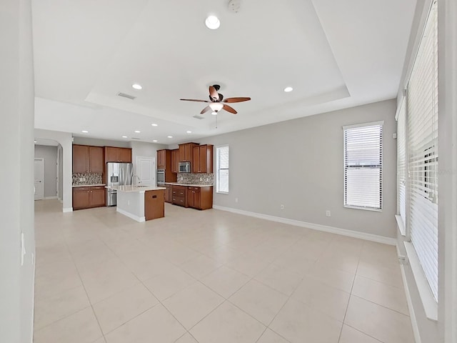 4063 Medicci Ln, Wesley Chapel, FL 33543 - kitchen with open floor plan, a tray ceiling, tasteful backsplash, light countertops, and recessed lighting