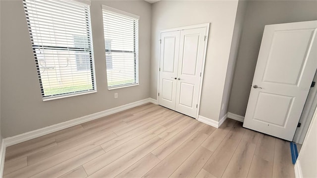 4063 Medicci Ln, Wesley Chapel, FL 33543 - unfurnished bedroom featuring baseboards, light wood-style flooring, and a closet