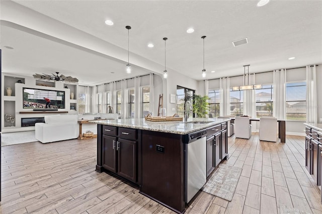 kitchen with dishwasher, light wood-style flooring, a sink, recessed lighting, and open floor plan
