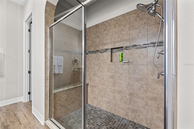 full bathroom with a stall shower and wood finished floors