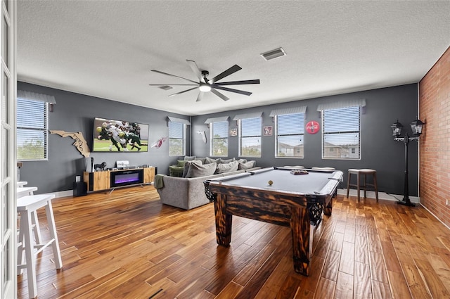 game room featuring light wood finished floors, ceiling fan, billiards, plenty of natural light, and a textured ceiling