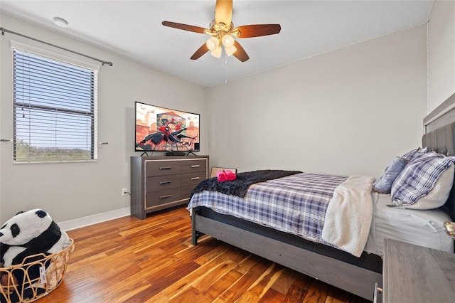 bedroom with baseboards, light wood-style floors, and a ceiling fan