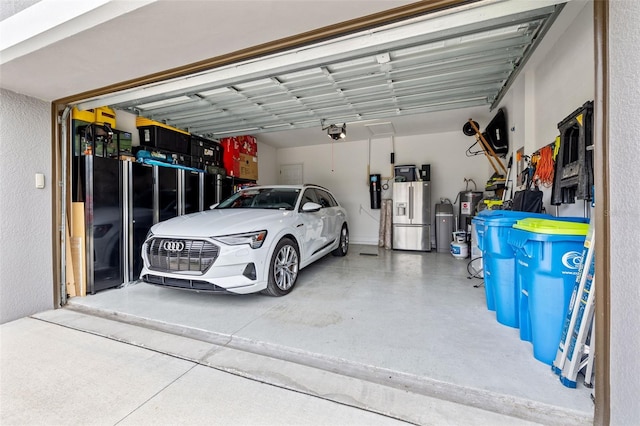 garage with a garage door opener and stainless steel refrigerator with ice dispenser