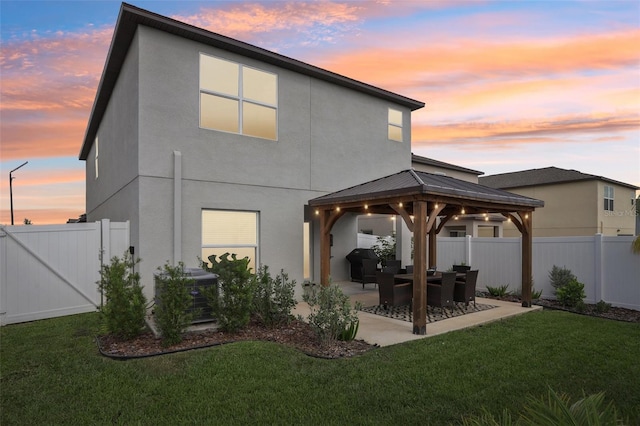 6398 Bar S Bar Trl, Zephyrhills, FL 33541 - back of house at dusk with a gazebo, stucco siding, a patio area, and central air condition unit