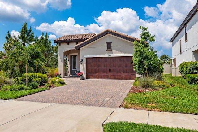 3877 Burdick Loop, Odessa, FL 33556 - mediterranean / spanish-style house with decorative driveway, a tile roof, a garage, stucco siding, and fence