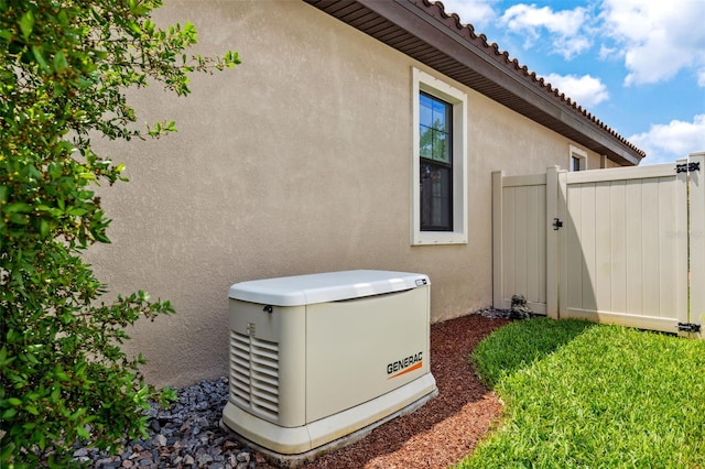 3877 Burdick Loop, Odessa, FL 33556 - exterior view of a power unit, stucco siding, fence, and a gate