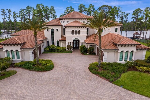 17124 Crawley Rd, Odessa, FL 33556 - mediterranean / spanish home featuring french doors, stucco siding, curved driveway, and an attached garage