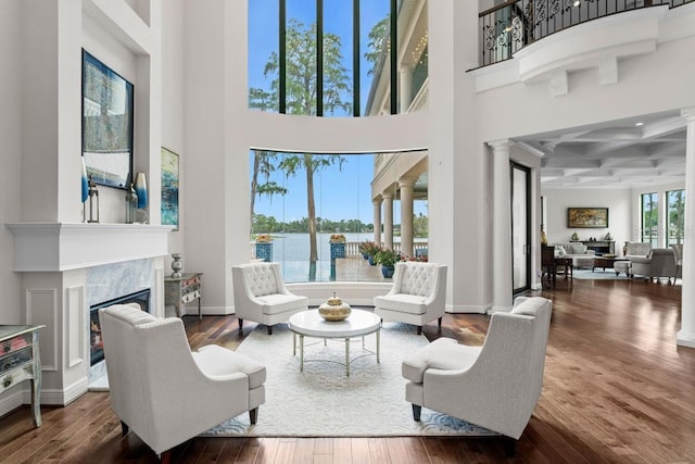 17124 Crawley Rd, Odessa, FL 33556 - living area featuring a high ceiling, ornate columns, a glass covered fireplace, hardwood / wood-style flooring, and coffered ceiling