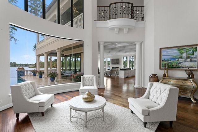 17124 Crawley Rd, Odessa, FL 33556 - living room with decorative columns, a high ceiling, wood finished floors, baseboards, and a water view