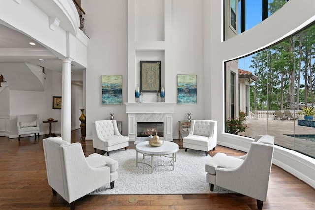17124 Crawley Rd, Odessa, FL 33556 - living room featuring ornate columns, a high ceiling, a premium fireplace, wood finished floors, and baseboards