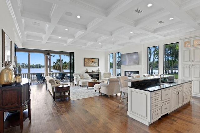 17124 Crawley Rd, Odessa, FL 33556 - living area with a glass covered fireplace, healthy amount of natural light, beamed ceiling, dark wood-style flooring, and coffered ceiling