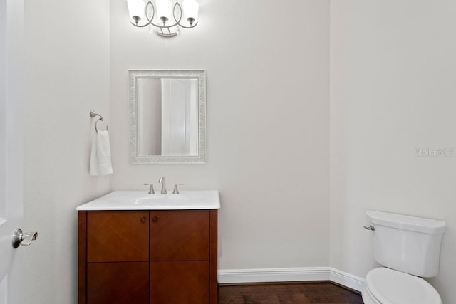 17124 Crawley Rd, Odessa, FL 33556 - half bathroom featuring vanity, toilet, baseboards, and wood finished floors
