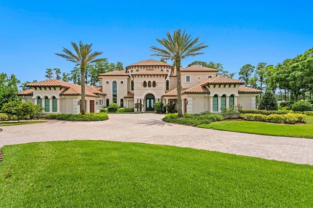 17124 Crawley Rd, Odessa, FL 33556 - mediterranean / spanish house featuring stucco siding, a front lawn, curved driveway, and french doors
