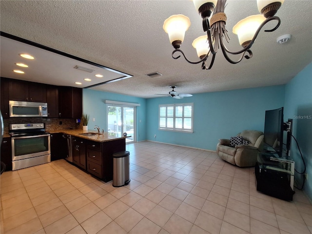 3357 Hunt Club Dr, Clearwater, FL 33761 - kitchen with appliances with stainless steel finishes, open floor plan, a sink, dark brown cabinetry, and decorative backsplash