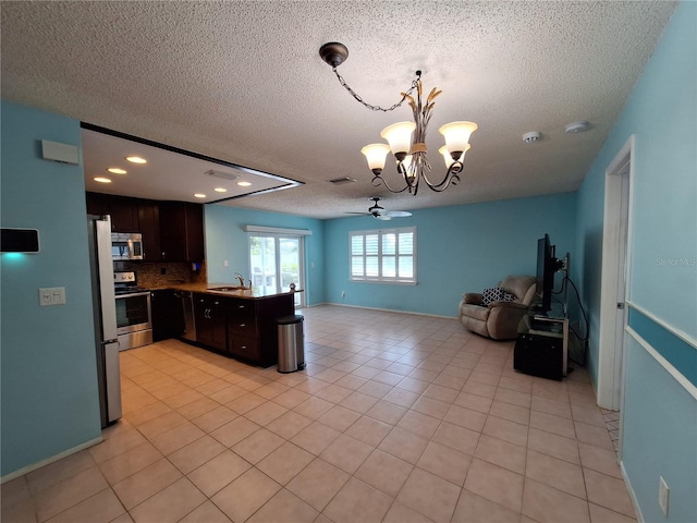 3357 Hunt Club Dr, Clearwater, FL 33761 - kitchen with appliances with stainless steel finishes, a sink, open floor plan, a chandelier, and dark brown cabinetry