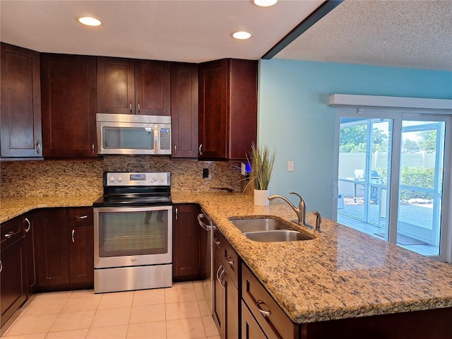 3357 Hunt Club Dr, Clearwater, FL 33761 - kitchen with stainless steel appliances, a sink, a peninsula, decorative backsplash, and light stone counters