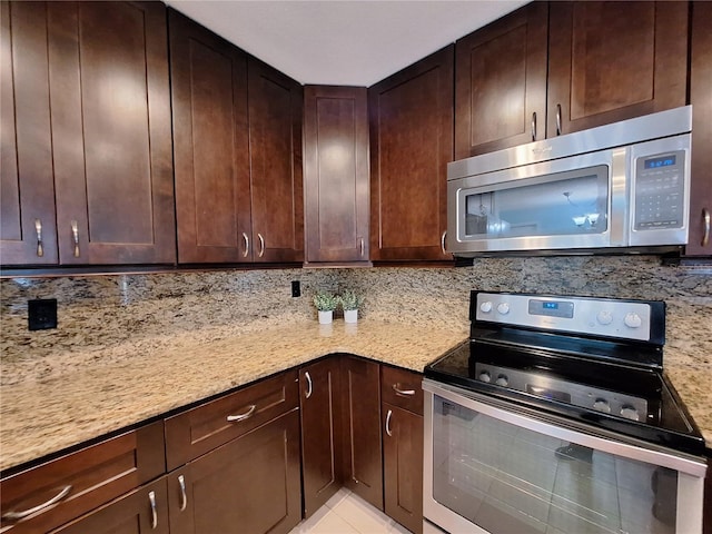 3357 Hunt Club Dr, Clearwater, FL 33761 - kitchen with stainless steel appliances, light stone countertops, dark brown cabinetry, and backsplash