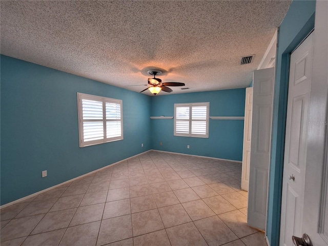 3357 Hunt Club Dr, Clearwater, FL 33761 - spare room featuring a ceiling fan, a textured ceiling, light tile patterned floors, and baseboards