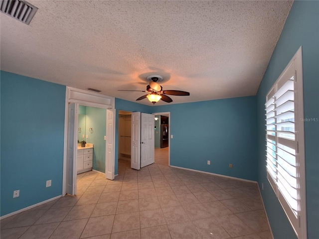 3357 Hunt Club Dr, Clearwater, FL 33761 - unfurnished bedroom with a textured ceiling, baseboards, a spacious closet, a closet, and a ceiling fan
