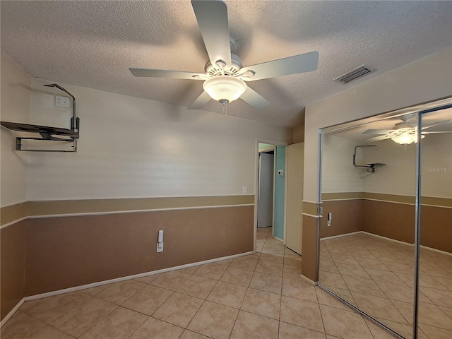 3357 Hunt Club Dr, Clearwater, FL 33761 - unfurnished bedroom with a textured ceiling, light tile patterned flooring, a closet, and a ceiling fan