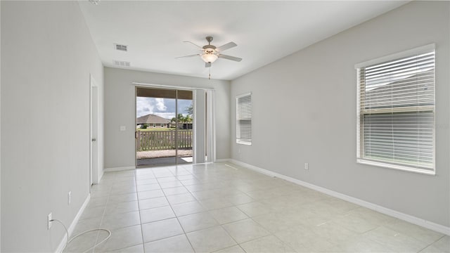 spare room featuring ceiling fan, light tile patterned floors, and baseboards