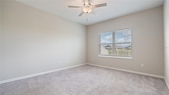 carpeted empty room with baseboards and a ceiling fan
