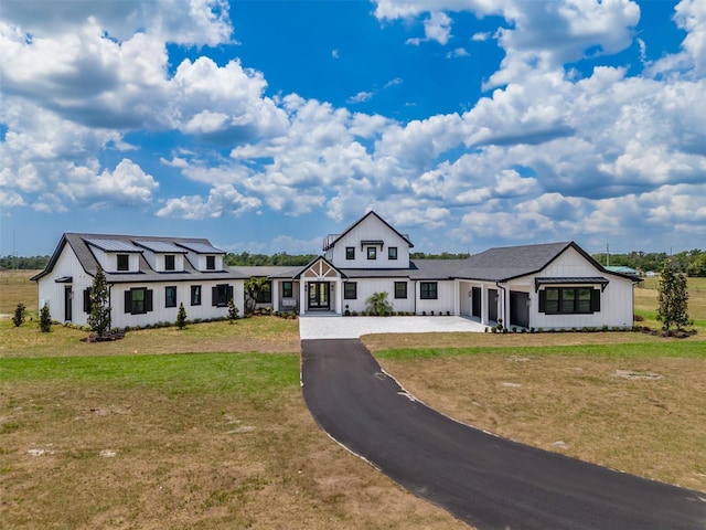 3515 Powerline Rd, Lithia, FL 33547 - modern farmhouse style home featuring a front yard, board and batten siding, and asphalt driveway