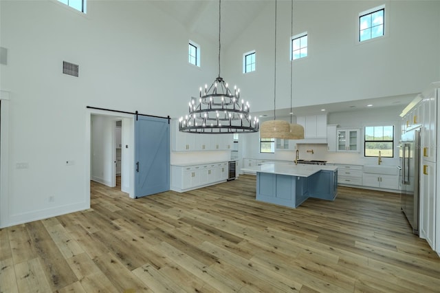 3515 Powerline Rd, Lithia, FL 33547 - kitchen featuring high vaulted ceiling, a barn door, high quality fridge, light countertops, and a chandelier
