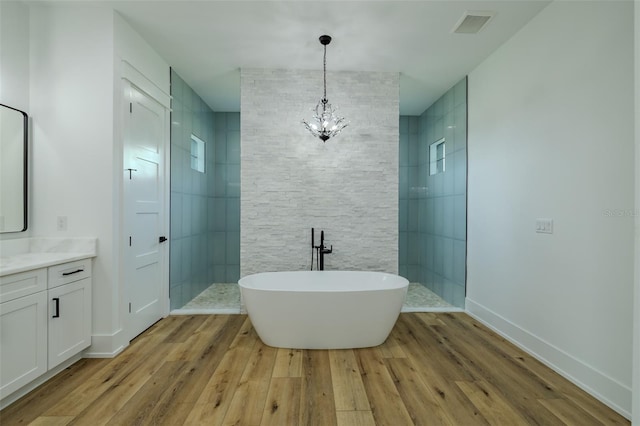 3515 Powerline Rd, Lithia, FL 33547 - full bathroom featuring wood finished floors, a walk in shower, vanity, and a soaking tub