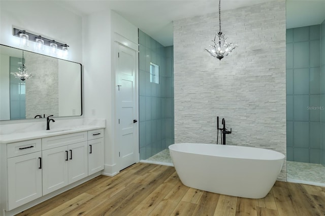 3515 Powerline Rd, Lithia, FL 33547 - bathroom featuring a chandelier, wood finished floors, a soaking tub, and vanity