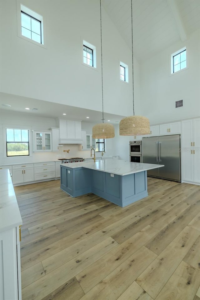 3515 Powerline Rd, Lithia, FL 33547 - kitchen featuring high vaulted ceiling, appliances with stainless steel finishes, light wood-style floors, white cabinets, and a sink