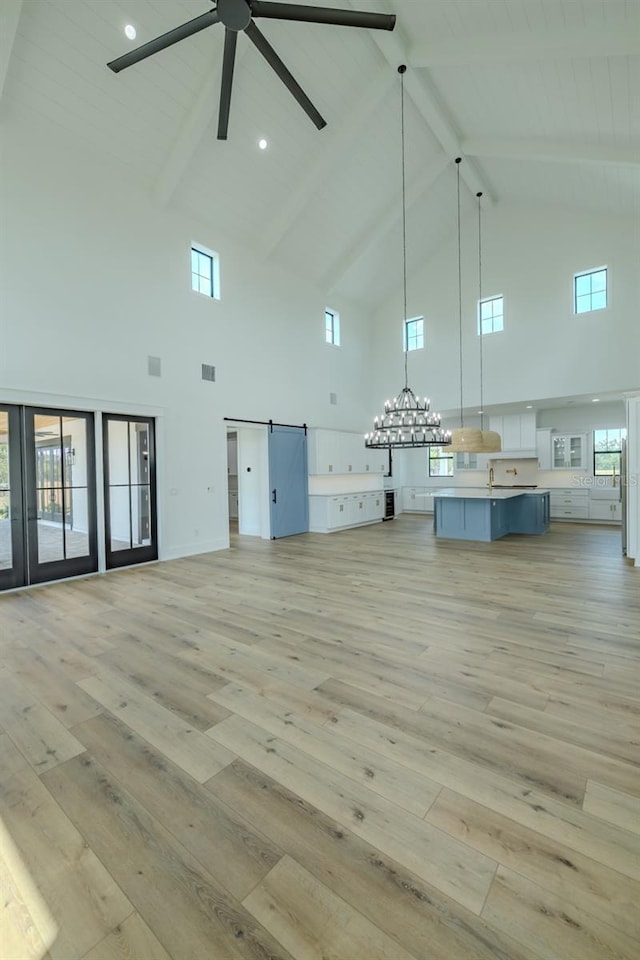 3515 Powerline Rd, Lithia, FL 33547 - misc room with high vaulted ceiling, a barn door, light wood-type flooring, ceiling fan, and beam ceiling