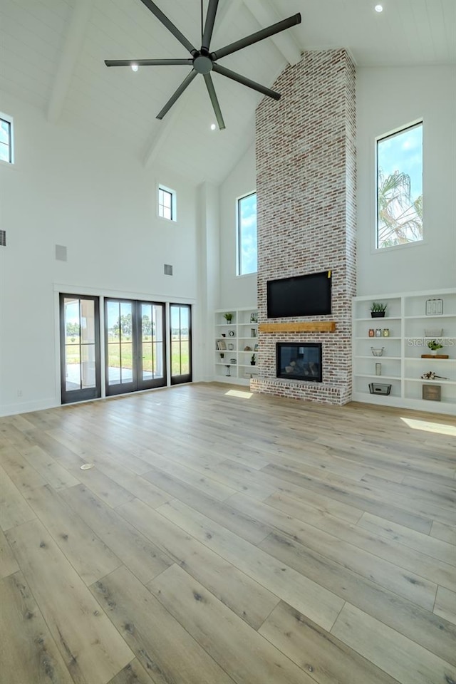 3515 Powerline Rd, Lithia, FL 33547 - unfurnished living room featuring high vaulted ceiling, a ceiling fan, a fireplace, hardwood / wood-style floors, and healthy amount of natural light