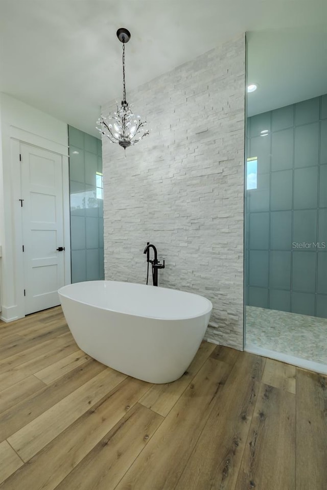 3515 Powerline Rd, Lithia, FL 33547 - bathroom featuring a freestanding bath, wood finished floors, walk in shower, and a chandelier