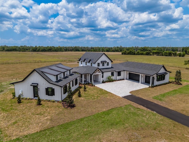 3515 Powerline Rd, Lithia, FL 33547 - view of front of house with driveway, a garage, a front lawn, a view of countryside, and board and batten siding