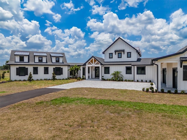 3515 Powerline Rd, Lithia, FL 33547 - modern farmhouse style home featuring board and batten siding, a front yard, and driveway