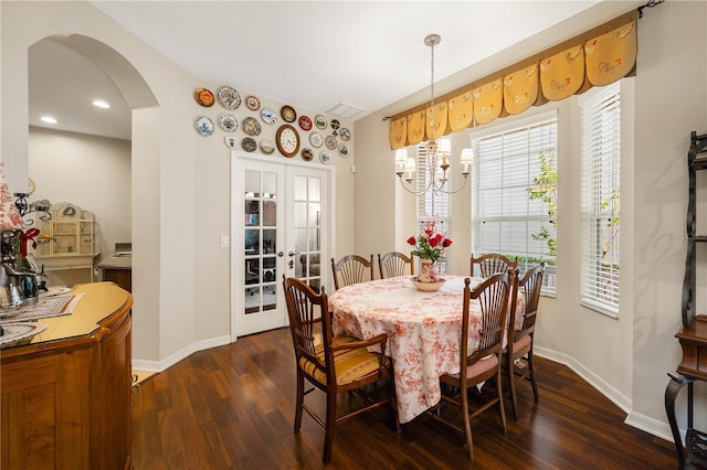 20039 Heritage Point Dr, Tampa, FL 33647 - dining room with arched walkways, dark wood finished floors, baseboards, a chandelier, and vaulted ceiling