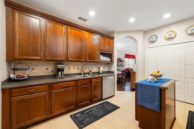 20039 Heritage Point Dr, Tampa, FL 33647 - kitchen with a sink, stainless steel dishwasher, arched walkways, dark countertops, and recessed lighting