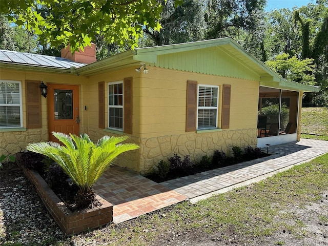 10170 W Yulee Dr, Homosassa, FL 34448 - view of side of home featuring a chimney, a sunroom, and concrete block siding