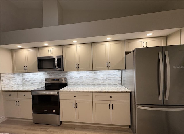 6533 Brentwood Dr, Zephyrhills, FL 33542 - kitchen featuring appliances with stainless steel finishes, light wood finished floors, decorative backsplash, light stone counters, and recessed lighting