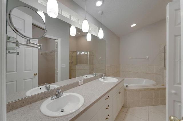 6801 Bishops Pointe Way, Riverview, FL 33578 - bathroom with tile patterned flooring, a garden tub, double vanity, a walk in closet, and recessed lighting