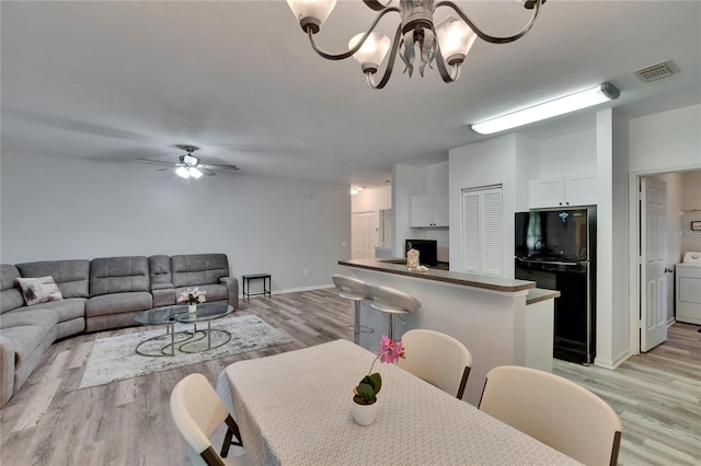 2220 Chianti Pl Unit 8-0828, Palm Harbor, FL 34683 - dining room featuring washer / dryer, light wood finished floors, a ceiling fan, baseboards, and a chandelier