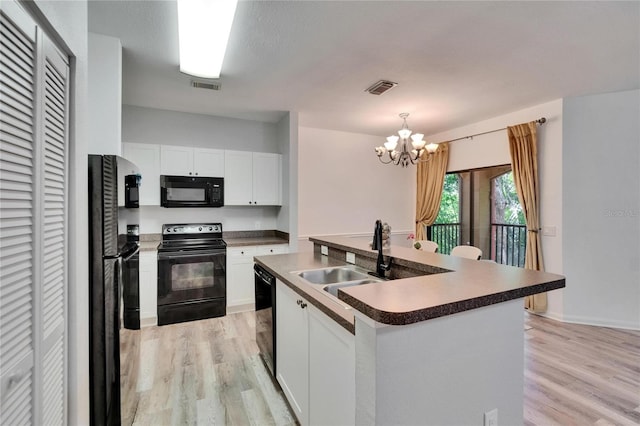 2220 Chianti Pl Unit 8-0828, Palm Harbor, FL 34683 - kitchen with black appliances, light wood-style floors, dark countertops, and a sink