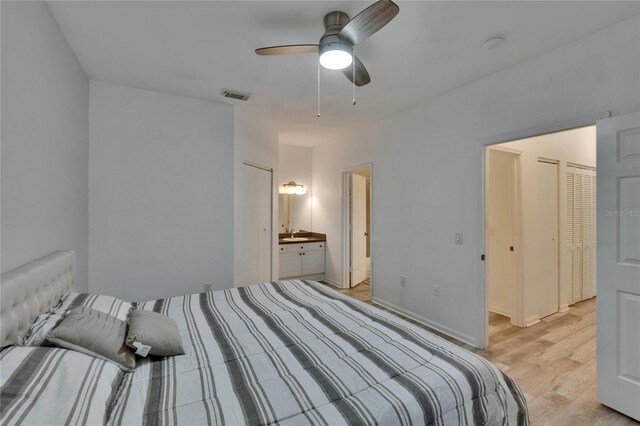 2220 Chianti Pl Unit 8-0828, Palm Harbor, FL 34683 - bedroom featuring light wood-type flooring, ensuite bathroom, and a ceiling fan