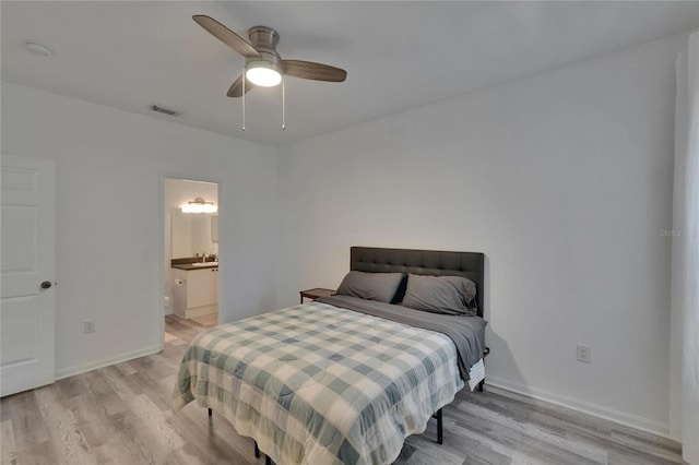 2220 Chianti Pl Unit 8-0828, Palm Harbor, FL 34683 - bedroom featuring light wood finished floors, baseboards, a ceiling fan, and ensuite bath